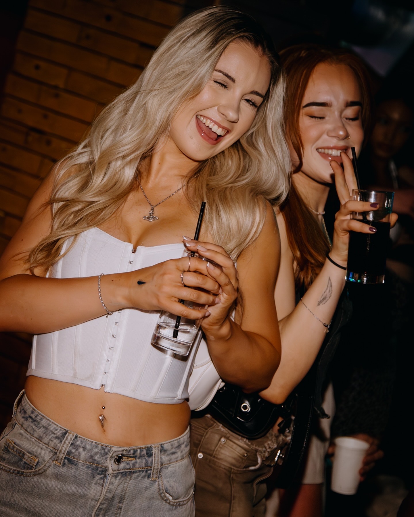 Two friends smiling with drinks at STEINS